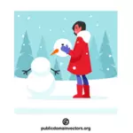 Flicka som gör en snögubbe