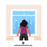 Nainen katselee lumisadetta